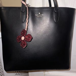 Kate Spade “Kerri” medium black tote with pink glitter flower fob. Excellent con